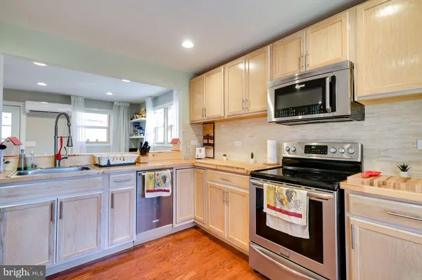 a kitchen with stainless steel appliances granite countertop a stove top oven a sink dishwasher and a microwave oven on the blue kitchen countertops