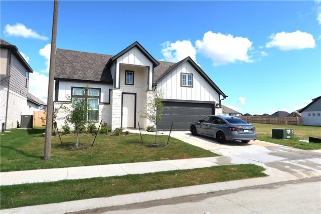 a view of a house with a big yard and potted plants