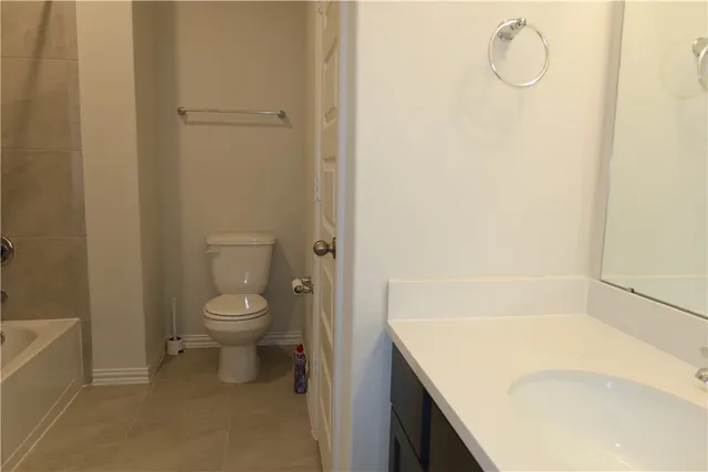 a bathroom with a granite countertop bathtub and toilet