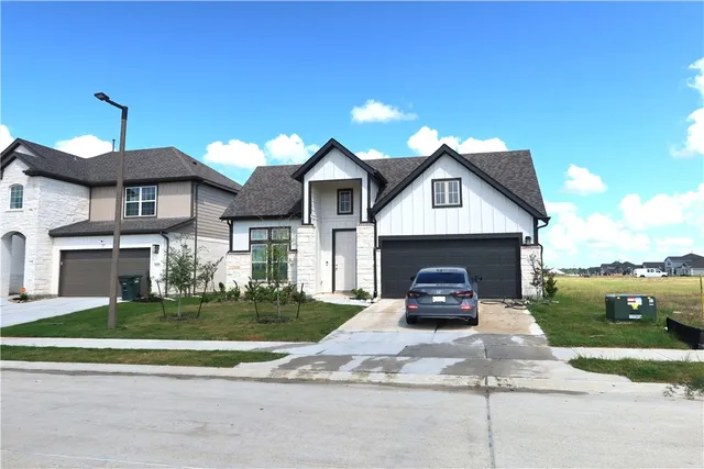 a car parked in front of a white house