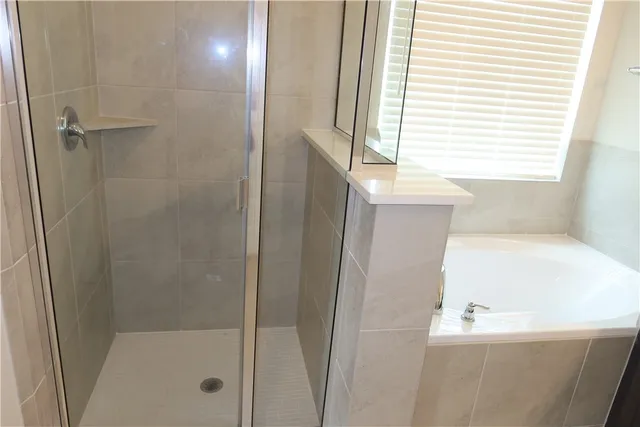 a bathroom with a bathtub and a shower
