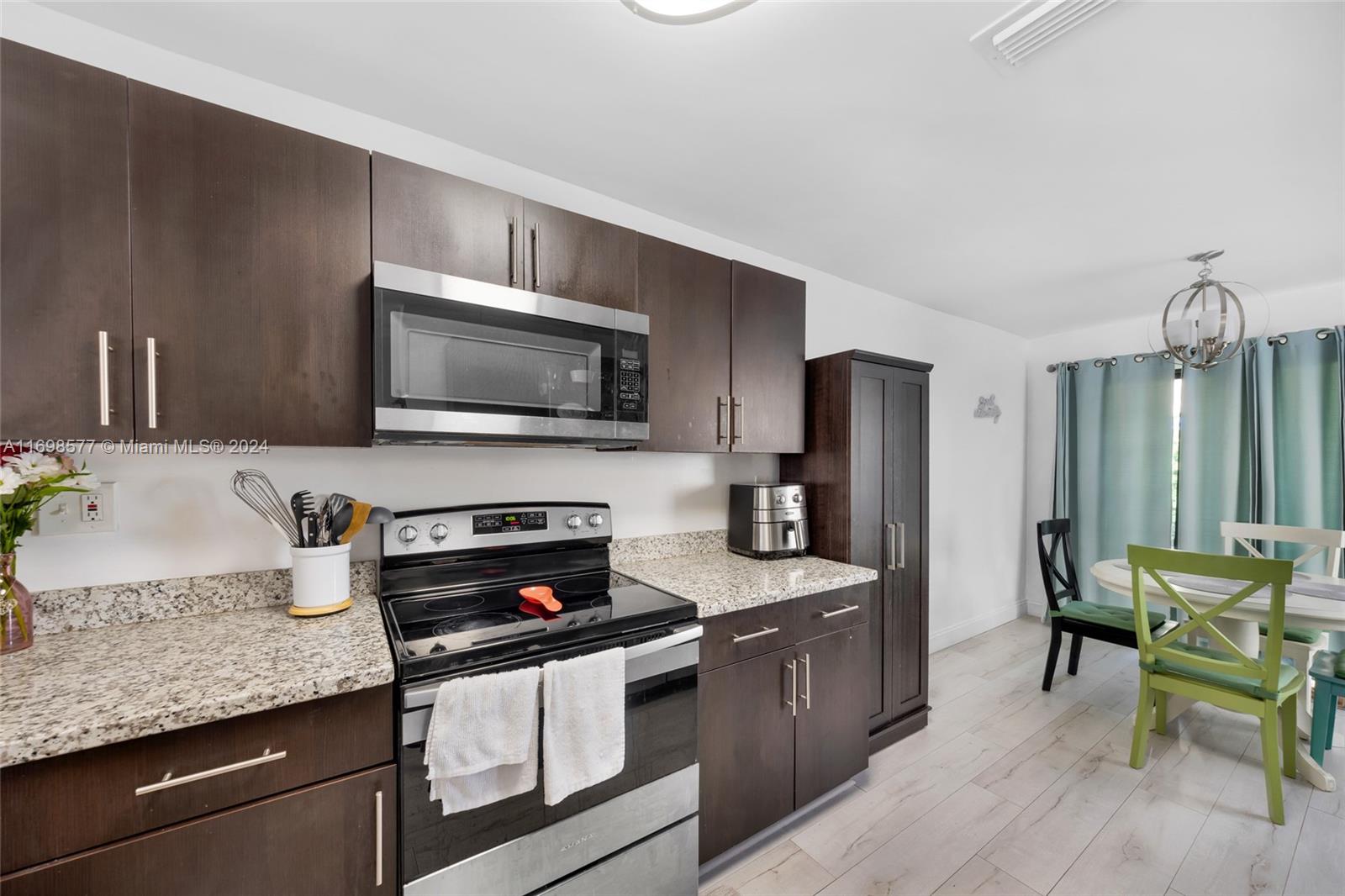 4440 Northeast 5th Avenue Boca Raton, FL 33431 - Photo 20 of 50 a kitchen with stainless steel appliances granite countertop a stove a sink dishwasher a microwave oven with granite countertops and cabinets