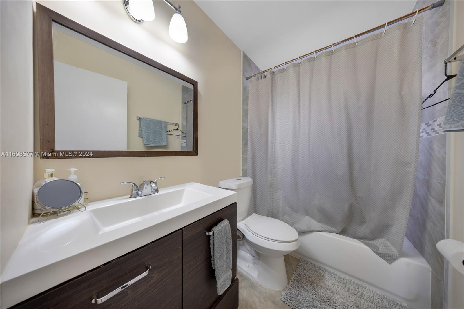4440 Northeast 5th Avenue Boca Raton, FL 33431 - Photo 31 of 50 a bathroom with a toilet a sink and mirror