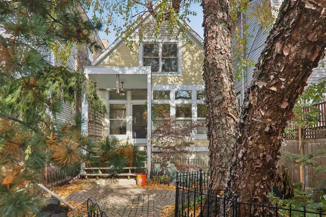 a view of a house with backyard and trees