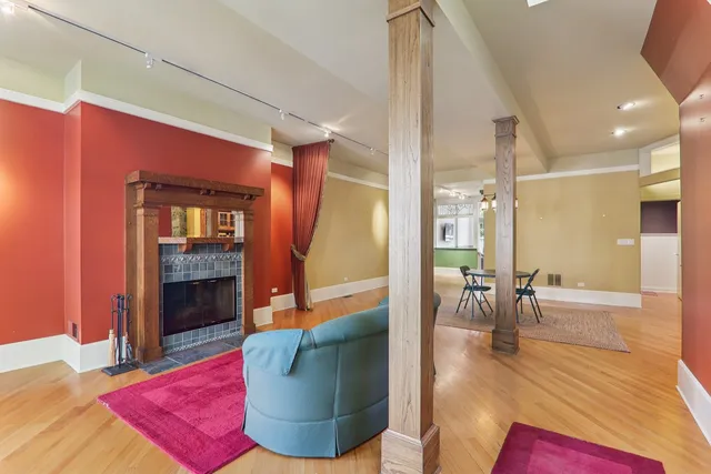 a dining room with wooden floor a chandelier a glass table and chairs
