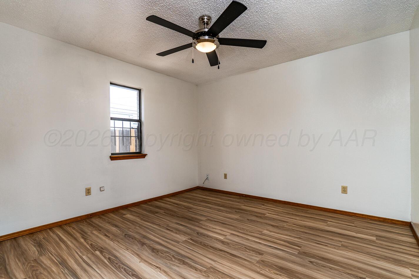 607 Mississippi Street Borger, TX 79007 - Photo 14 of 23 an empty room with wooden floor and windows