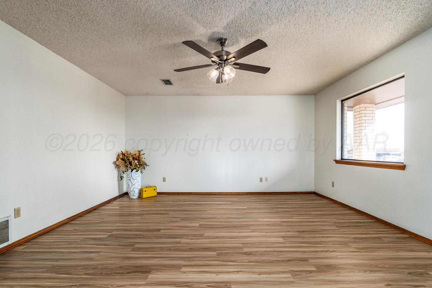 607 Mississippi Street Borger, TX 79007 - Photo 9 of 23 a view of an empty room with wooden floor and a window
