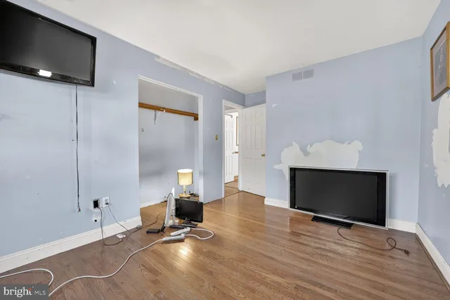 a room with a wooden floor and white walls