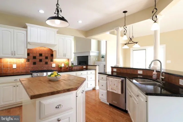 a kitchen with granite countertop a sink a stove and cabinets