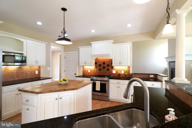 a kitchen with stainless steel appliances granite countertop a sink a stove and a refrigerator