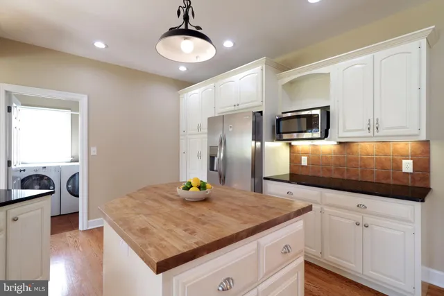 a kitchen with stainless steel appliances granite countertop a sink a microwave cabinets and wooden floor