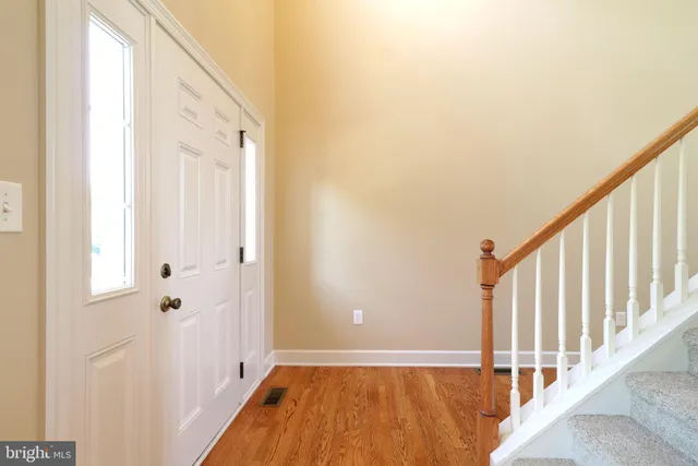 a view of a hallway with wooden floor and staircase