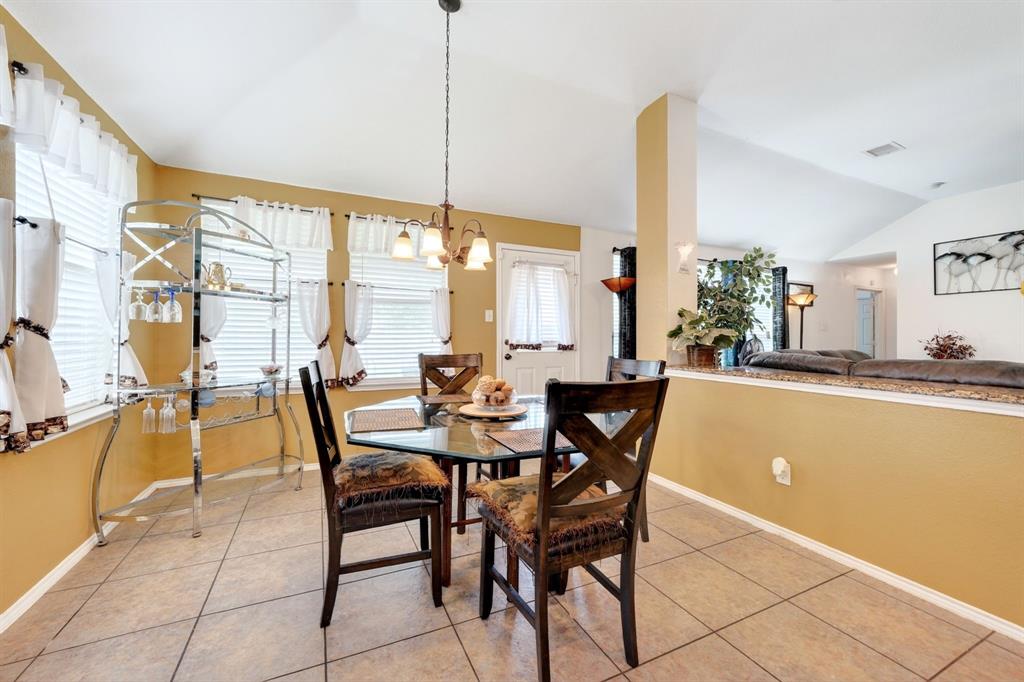 511 Chestnut Trail Forney, TX 75126 - Photo 16 of 32 Dining area featuring tile flooring, vaulted ceilings, and a decorative chandelier