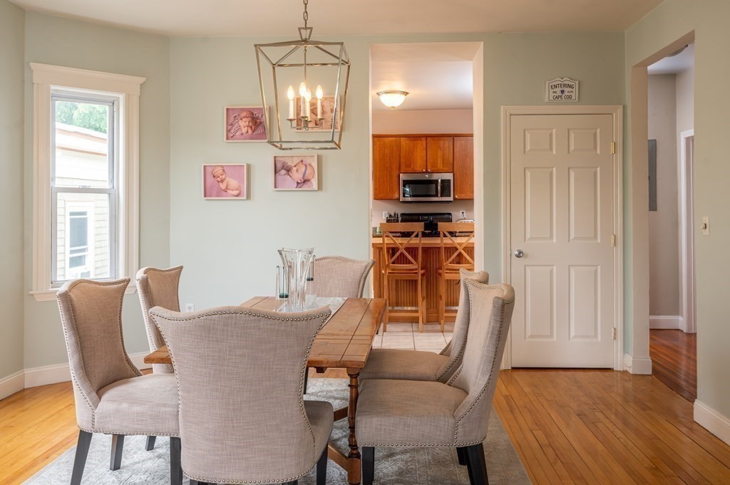 12 Thelma Road, Unit 3 Boston, MA 02122 - Photo 6 of 18 a view of a dining room with furniture a chandelier and wooden floor