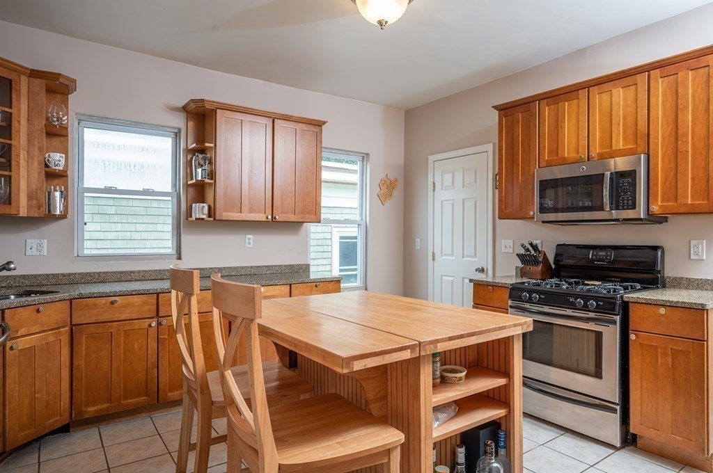 12 Thelma Road, Unit 3 Boston, MA 02122 - Photo 7 of 18 a kitchen with a stove a sink and a microwave