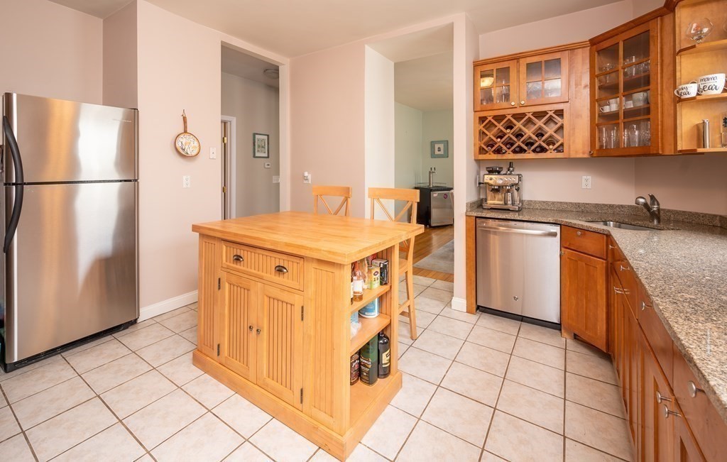 12 Thelma Road, Unit 3 Boston, MA 02122 - Photo 9 of 18 a kitchen with stainless steel appliances granite countertop a refrigerator and a stove