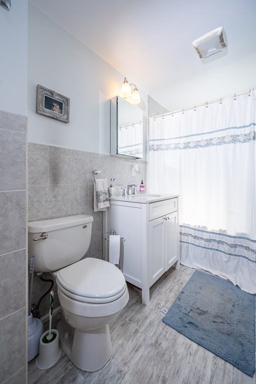 12 Thelma Road, Unit 3 Boston, MA 02122 - Photo 10 of 18 a bathroom with a sink a toilet and a mirror