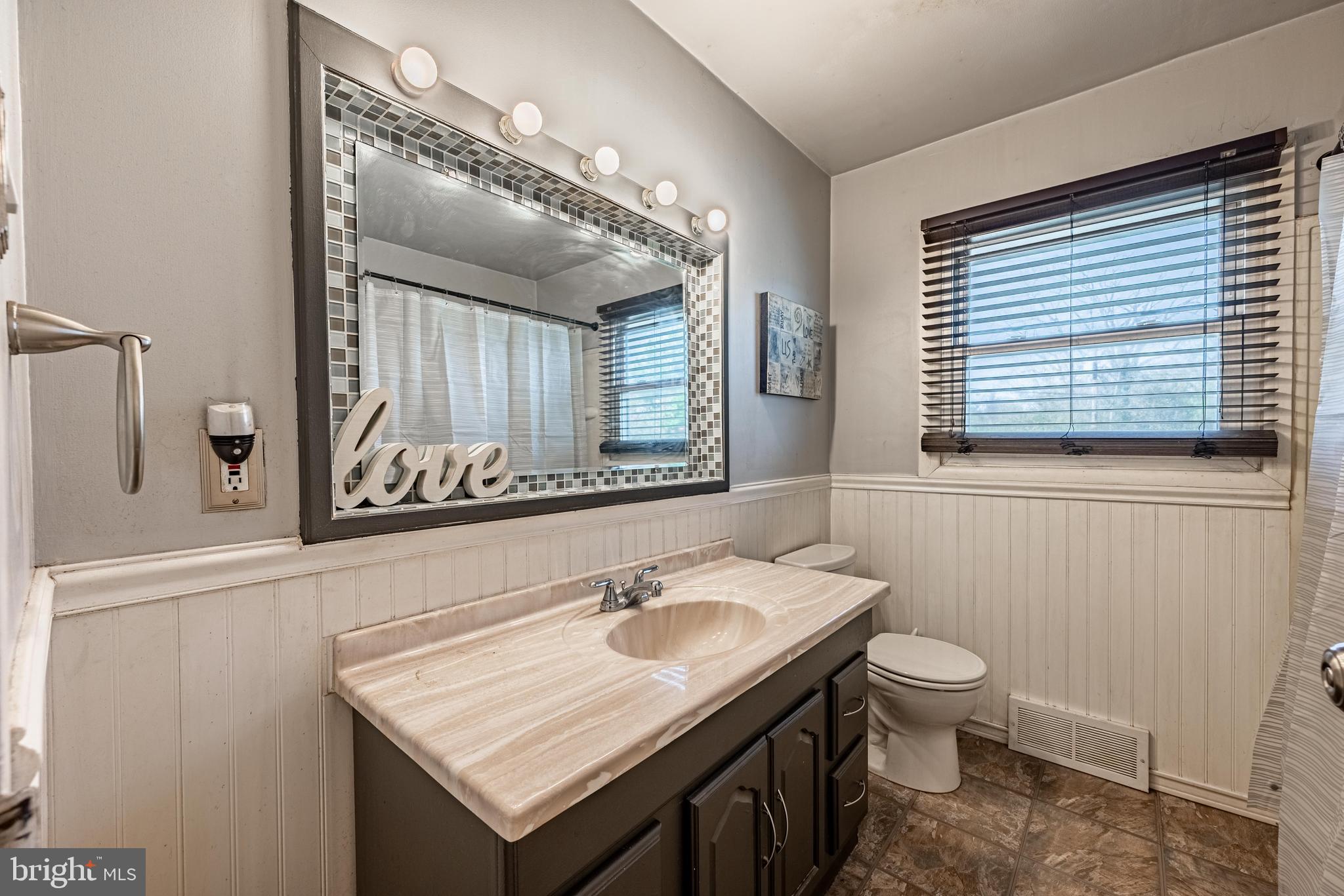3621 Washington Avenue Baltimore, MD 21244 - Photo 16 of 25 a bathroom with a sink toilet and mirror