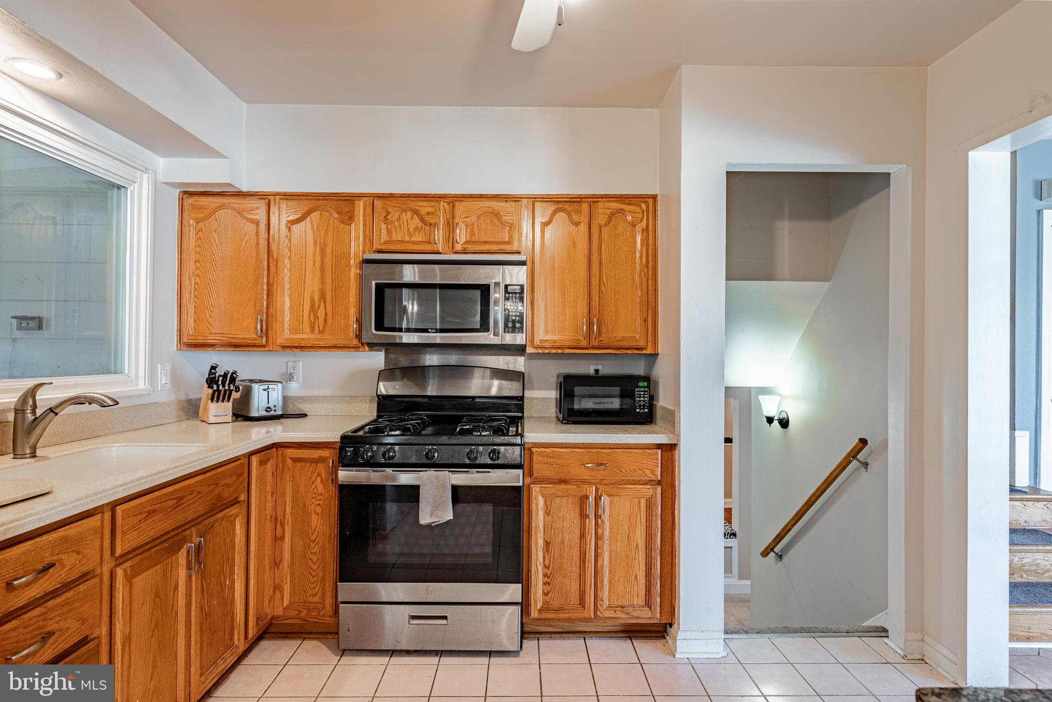 3621 Washington Avenue Baltimore, MD 21244 - Photo 10 of 25 a kitchen with granite countertop a stove a sink and a microwave