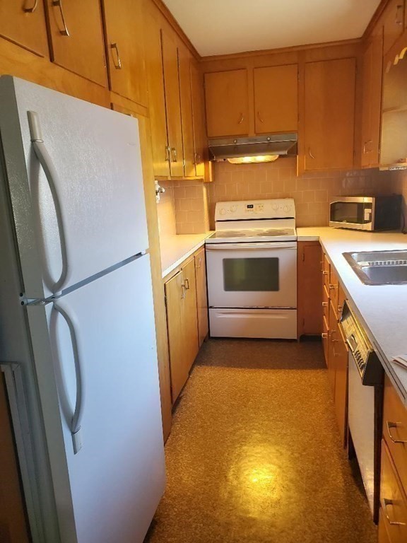 545 Robeson Street Fall River, MA 02720 - Photo 19 of 42 a kitchen with a refrigerator sink stove and cabinets