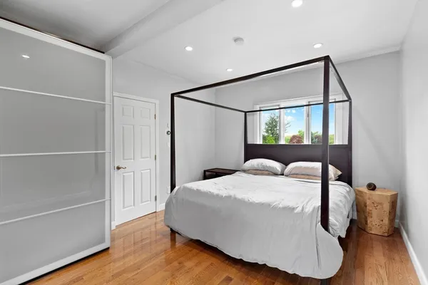 a bedroom with a bed and wooden floor