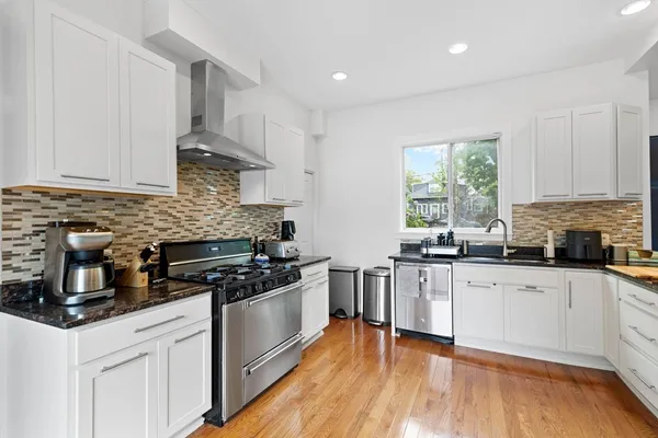 a kitchen with stainless steel appliances granite countertop wooden cabinets stove top oven and sink