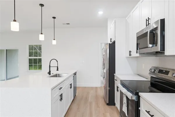 a kitchen with stainless steel appliances granite countertop a sink a stove and a refrigerator