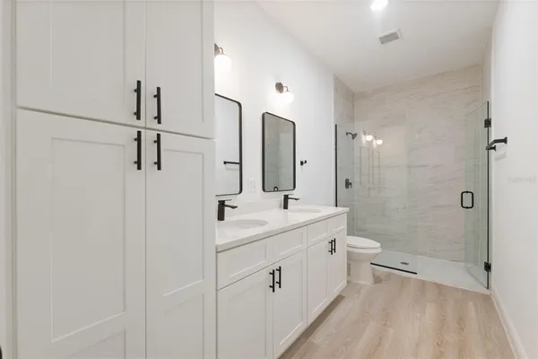 a bathroom with a double vanity sink toilet and shower