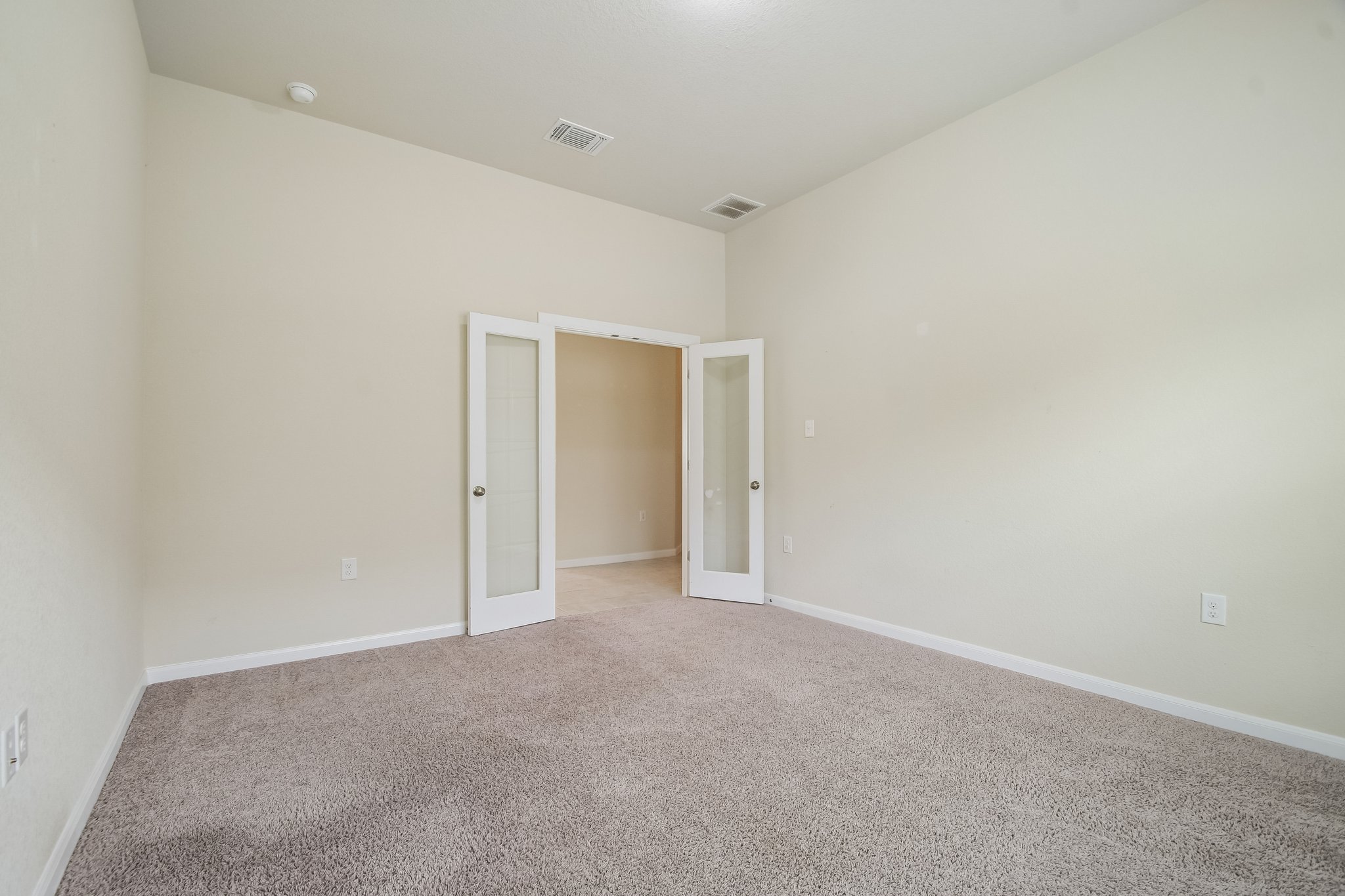 280 Rimrock Court Bastrop, TX 78602 - Photo 17 of 34 Double French doors open into a versatile home office or bedroom featuring soft plush carpeting.