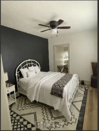 a bedroom with a bed and wooden floor