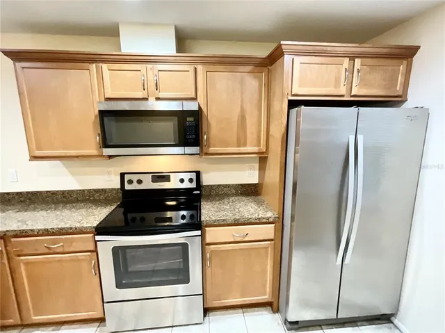a kitchen with stainless steel appliances granite countertop a refrigerator stove and microwave