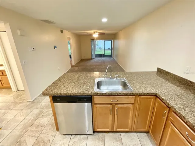a view of kitchen island with granite countertop sink