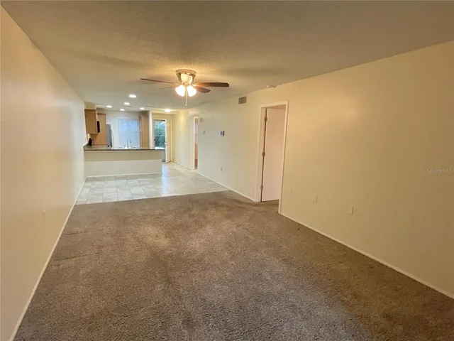 a view of a big room with chandelier fan and windows