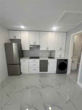 a kitchen with stainless steel appliances a refrigerator sink and cabinets