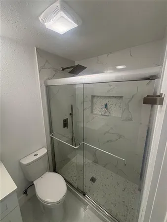 a bathroom with a toilet and a shower