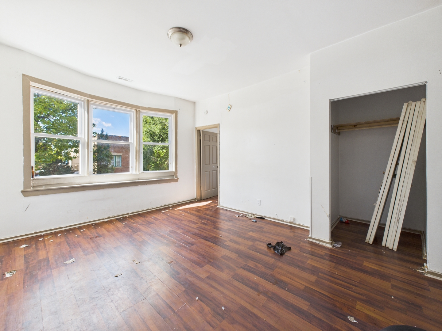 8709 South Escanaba Avenue Chicago, IL 60617 - Photo 11 of 31 a view of an empty room with wooden floor and a window
