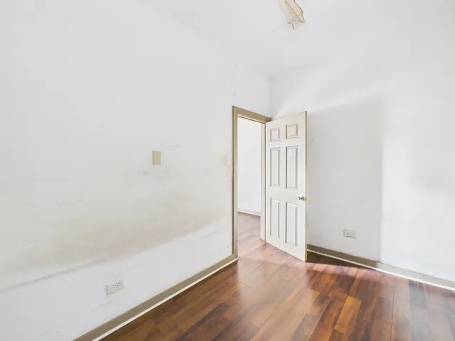 a view of a hallway with wooden floor and closet