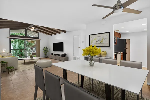 a kitchen with a table chairs refrigerator and microwave