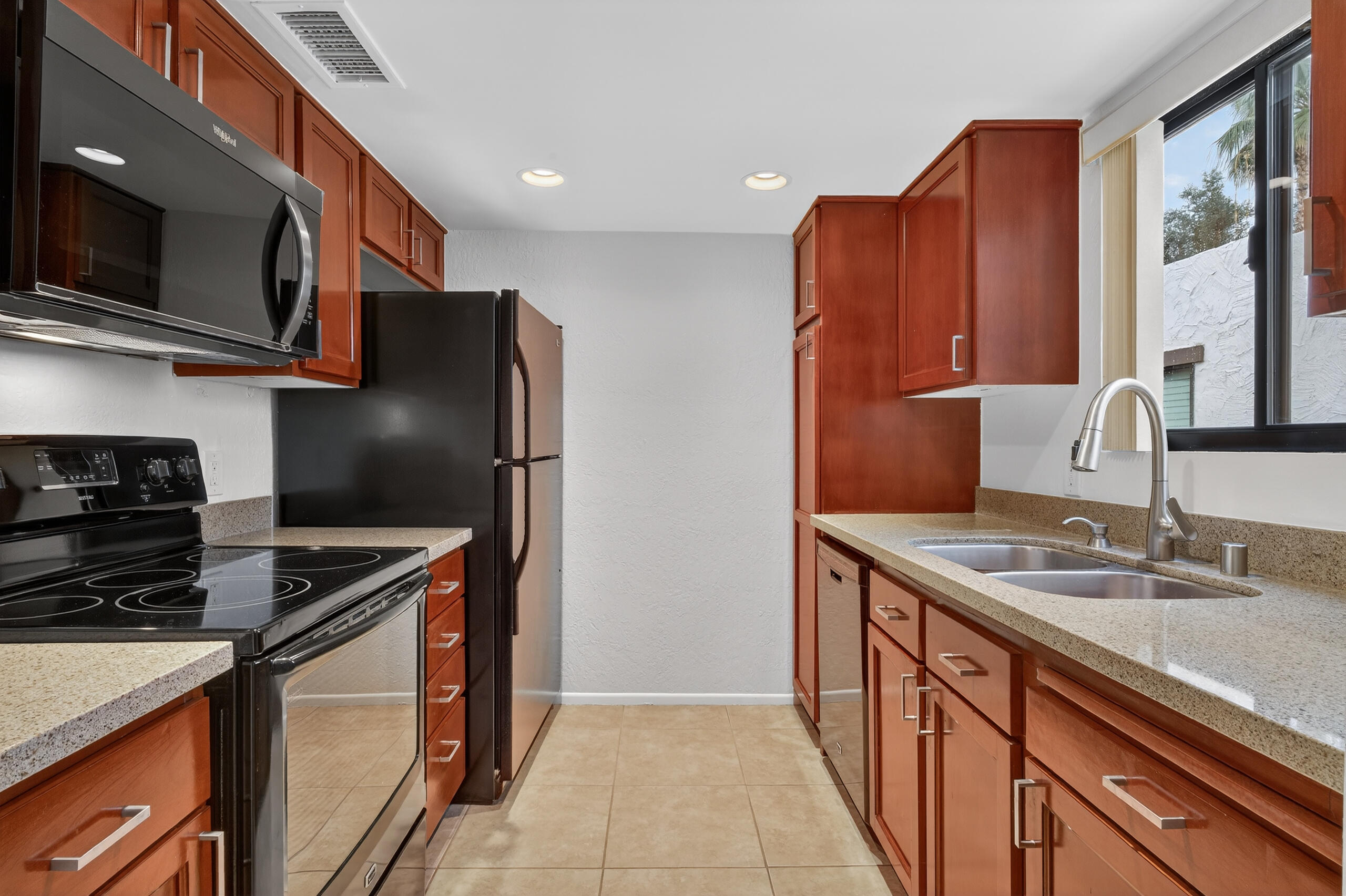 1050 Ramon Road, Unit 127 Palm Springs, CA 92264 - Photo 12 of 29 a kitchen with stainless steel appliances granite countertop a refrigerator a stove top oven a sink and dishwasher
