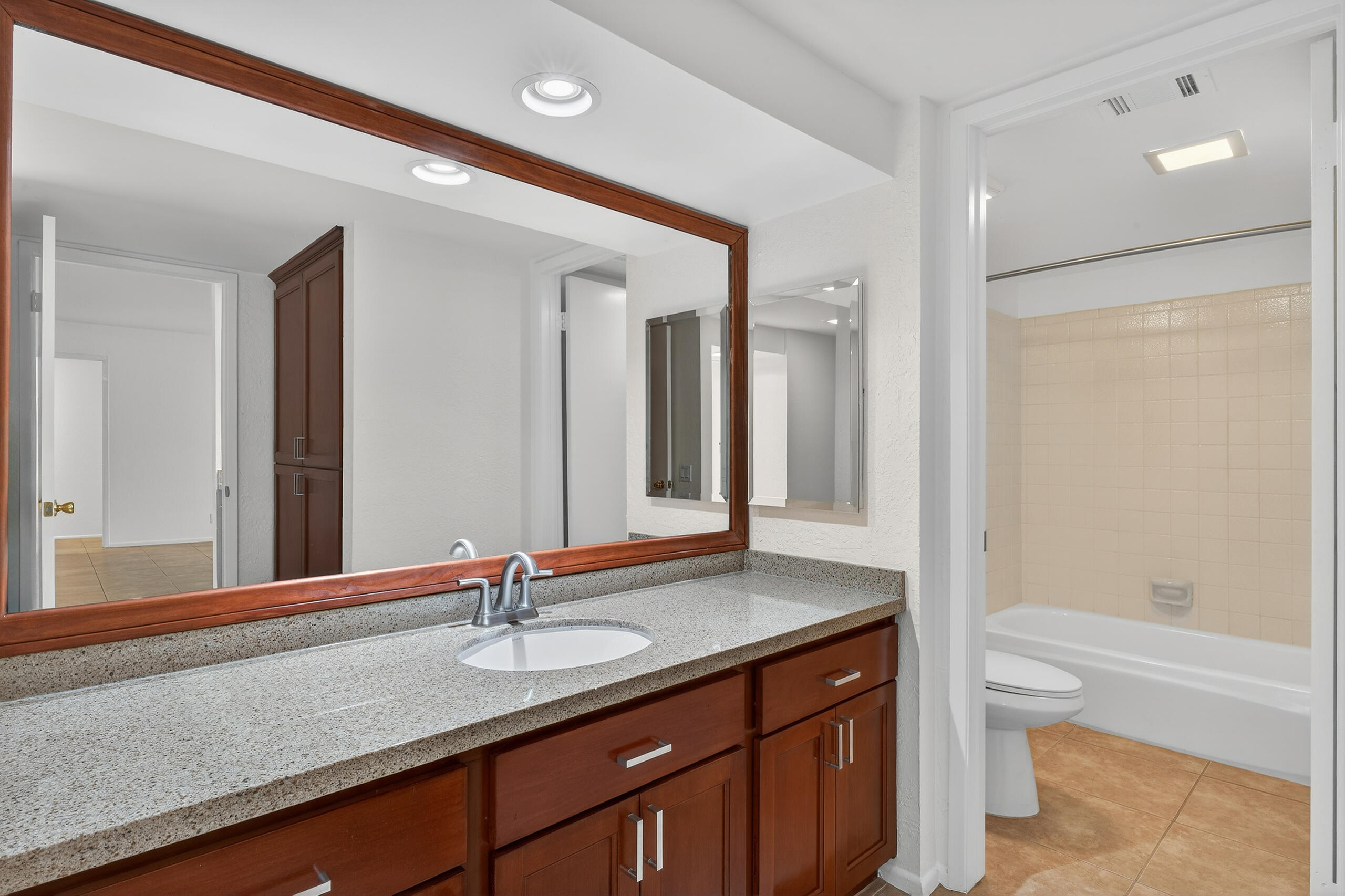 1050 Ramon Road, Unit 127 Palm Springs, CA 92264 - Photo 15 of 29 a bathroom with a granite countertop sink a toilet and a large mirror
