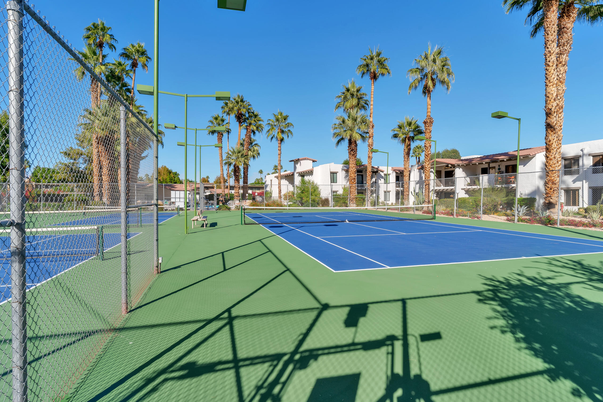 1050 Ramon Road, Unit 127 Palm Springs, CA 92264 - Photo 25 of 29 a view of a tennis ground with large trees