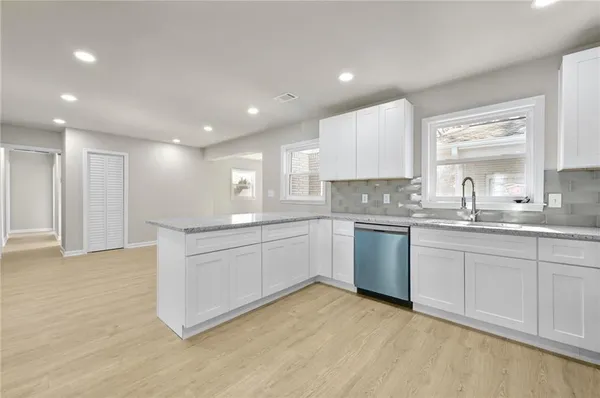 a kitchen with granite countertop a sink stainless steel appliances and cabinets