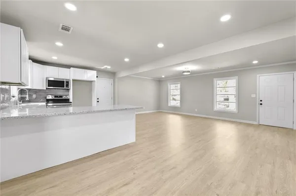 a view of kitchen with stove and cabinets
