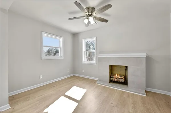 a view of an empty room with window and wooden floor