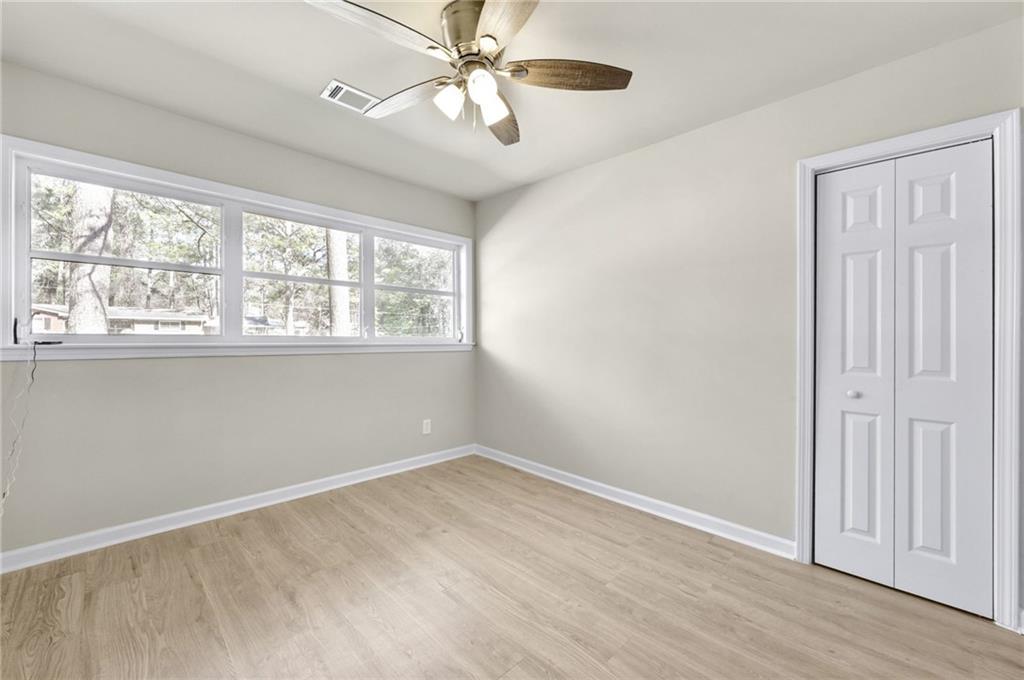 1963 Shepherd Circle Southwest Atlanta, GA 30311 - Photo 18 of 40 an empty room with wooden floor fan and windows