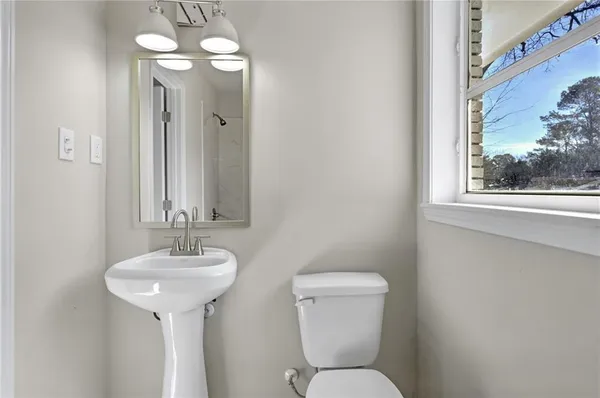 a bathroom with a toilet sink and mirror