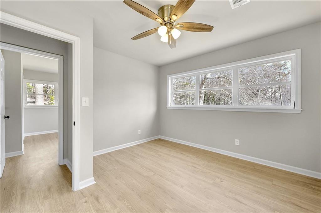1963 Shepherd Circle Southwest Atlanta, GA 30311 - Photo 27 of 40 an empty room with wooden floor chandelier fan and windows