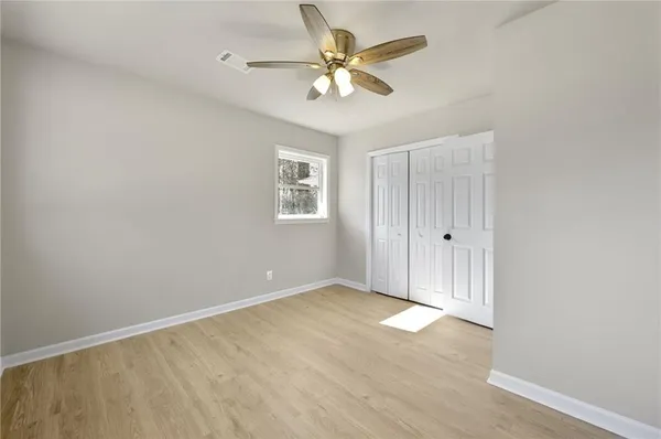 an empty room with windows and fan