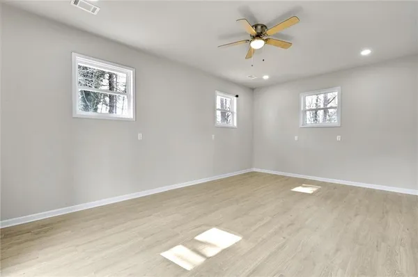 an empty room with a window and a ceiling fan