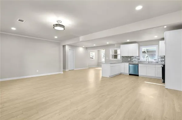 a view of kitchen with kitchen island a sink wooden floor and white appliances